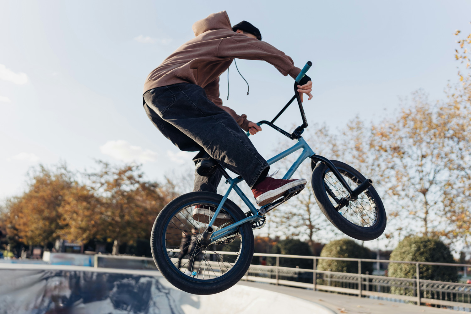 Nastolatek wykonuje skok na rowerze BMX w skateparku